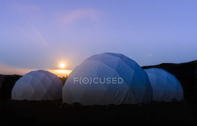 Tres tiendas de campaña de cúpula blanca al atardecer, Narsaq, Vestgronland, Groenlandia del Sur - foto de stock