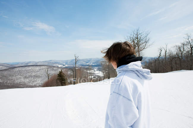 Jovem olhando para a paisagem nevada — Fotografia de Stock