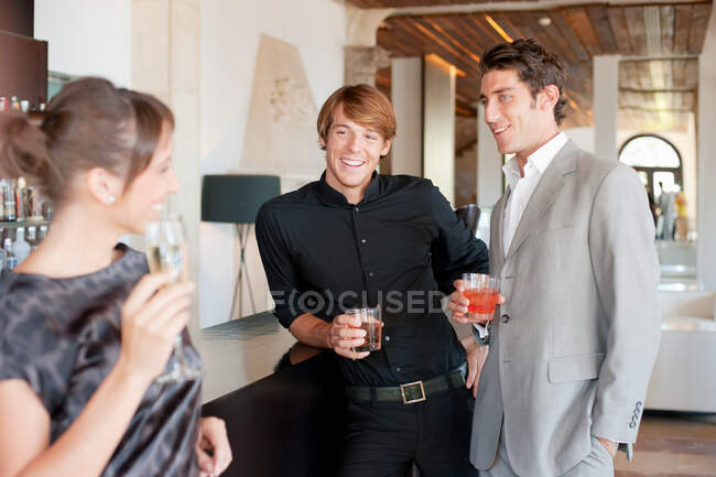 Due uomini che flirtano con una donna nel bar — Foto stock