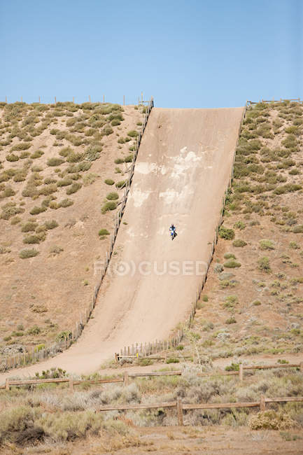 Hombre montando en bicicleta de tierra en la colina pista de tierra - foto de stock