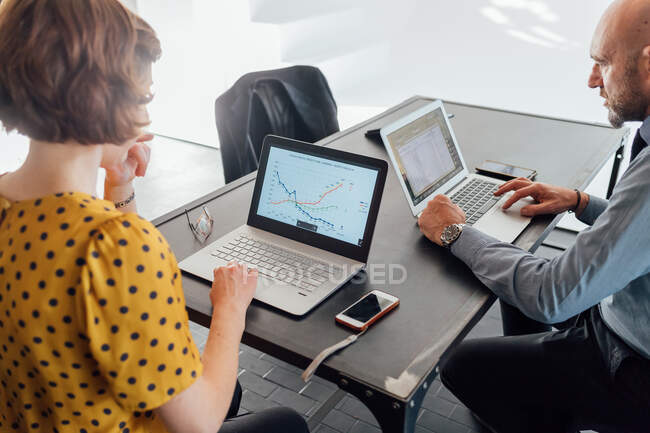 Colleagues at desk using laptops — Stock Photo