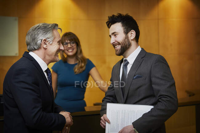 Dos hombres de negocios reunidos en recepción - foto de stock
