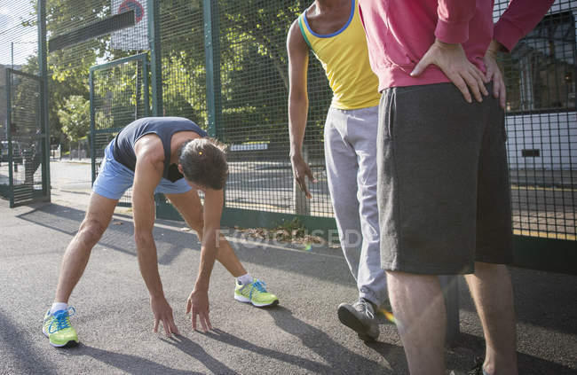 Trois hommes mûrs s'échauffent sur le terrain de basket — Photo de stock