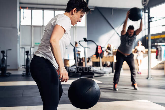 Люди в спортзалі використовують медичний м'яч — стокове фото