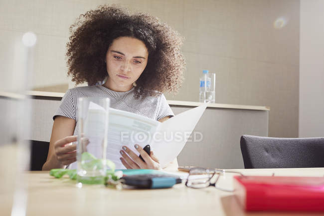 Businesswoman at office desk looking at paperwork — Stock Photo
