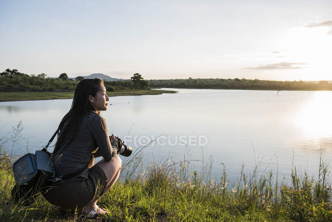 Junge Touristin blickt über den Fluss im Kruger Nationalpark, Südafrika — Stockfoto