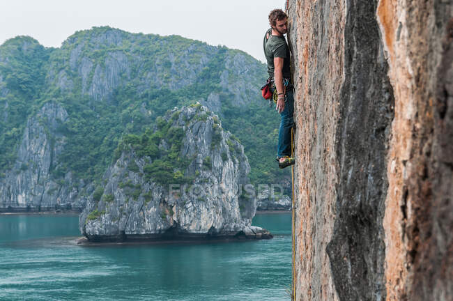 Uomo arrampicata su roccia calcarea, Ha Long Bay, Vietnam — Foto stock