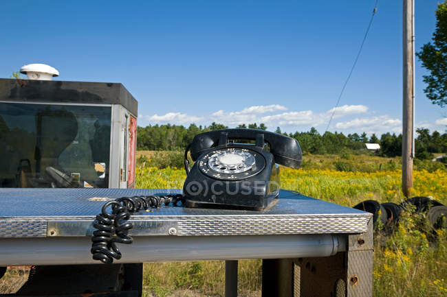 View of old black phone on metal desk on nature background — Stock Photo