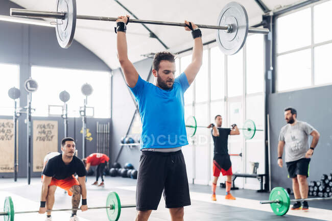 Man weightlifting barbell in gym — Stock Photo