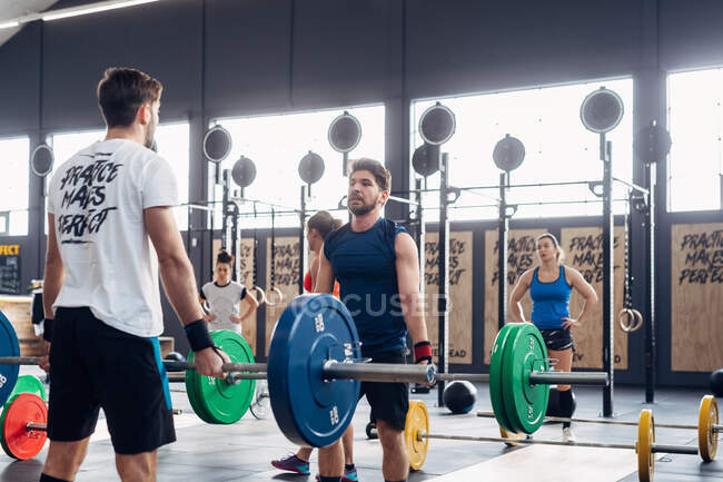 Men weightlifting with barbells in gym — Stock Photo
