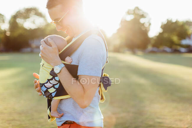 Батько, що носить маленького хлопчика в дитячому носії — стокове фото