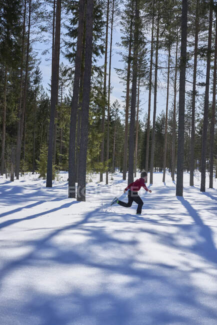 Giovane ragazzo che corre nella neve coperto paesaggio rurale — Foto stock