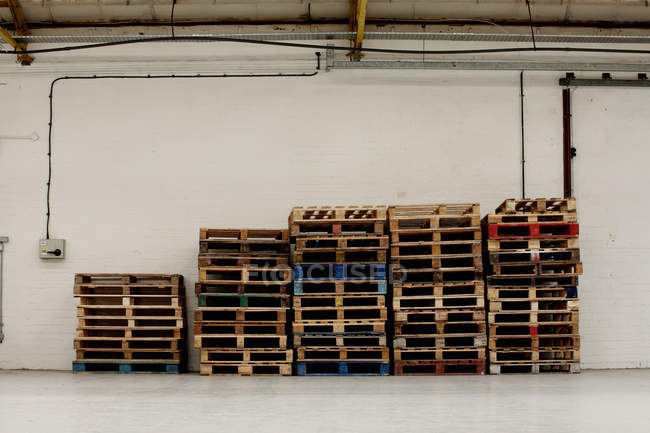 Стопка поддонов на пустом складе — стоковое фото