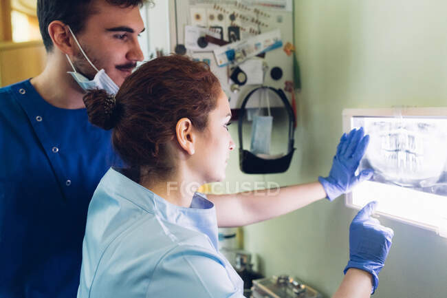Two dentists in dentist office, looking at dental x-ray — Stock Photo