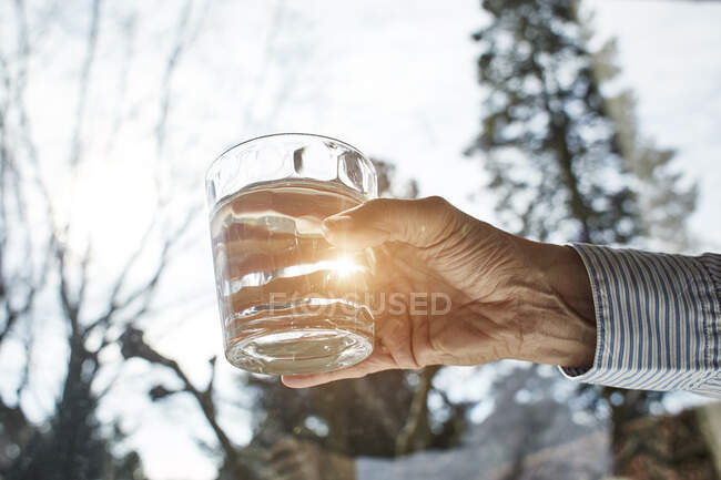 Senior woman holding glass of water, close-up — Stock Photo