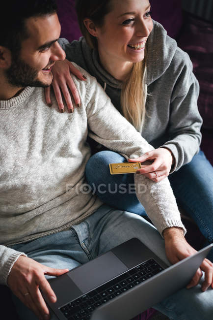Пара с кредитной картой с помощью ноутбука — стоковое фото