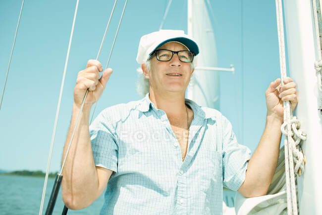 Hombre maduro en barco de vela - foto de stock