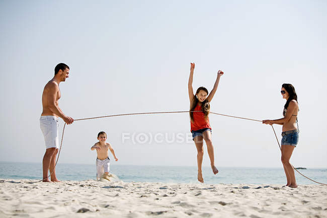 Familia celebración de la competencia de funcionamiento en una playa - foto de stock