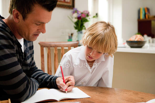 Vater hilft Sohn bei den Hausaufgaben — Stockfoto