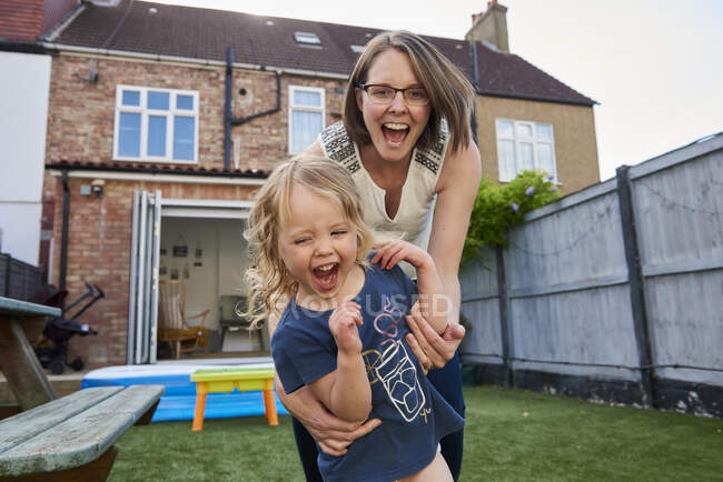 Mother and toddler daughter playing in garden, portrait — Stock Photo