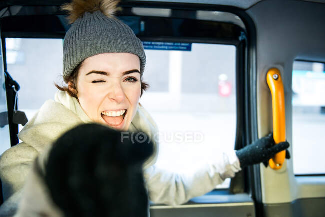 Retrato de jovem mulher na parte de trás do táxi, sorrindo, apontando — Fotografia de Stock