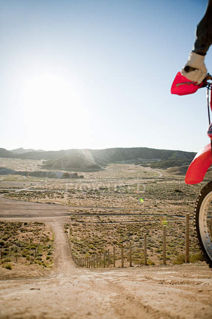 Обрезанный образ человека с велосипедом на холме — стоковое фото