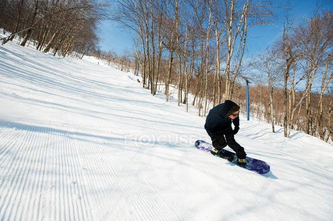 Чоловік катається на сноуборді в захопленому лісі — стокове фото