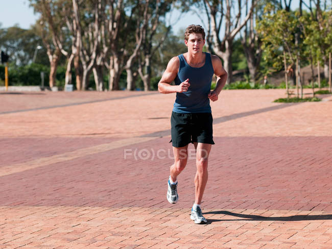 Young man running outdoors — Stock Photo