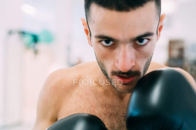 Retrato de homem em luvas de boxe olhando para a câmera — Fotografia de Stock