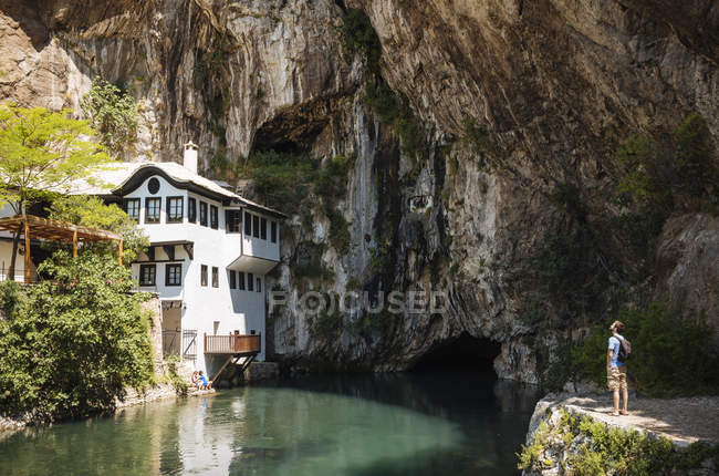 Hombre mirando la casa Dervish en Blagaj Japra, República Srpska, Bosnia y Herzegovina, Europa - foto de stock