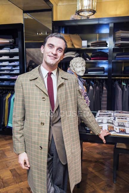 Male customer in traditional raincoat in tailors shop — Stock Photo