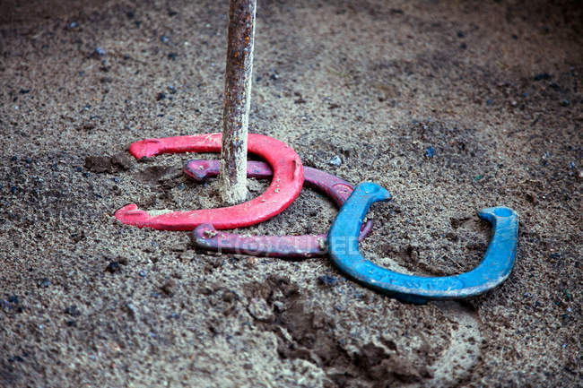 Vista de cerca de las herraduras de colores en el suelo, concepto de juego de herraduras - foto de stock
