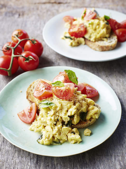 Huevos revueltos con tomates, sobre pan, primer plano - foto de stock