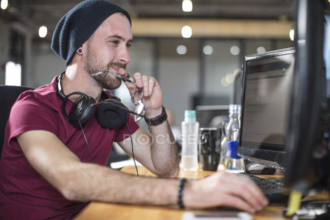 Young man working at his computer in office — Stock Photo