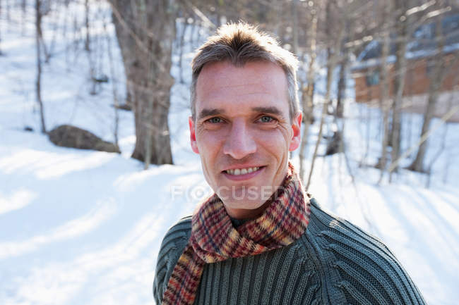 Портрет человека в снежном пейзаже, смотрящего в камеру — стоковое фото