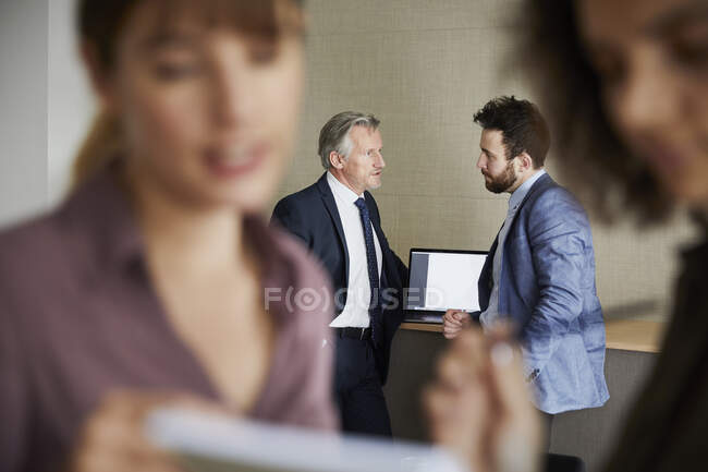 Colleagues in office chatting, focus on background — Stock Photo