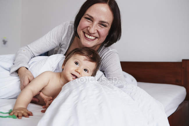 Мать и маленькая дочь отдыхают на кровати — стоковое фото