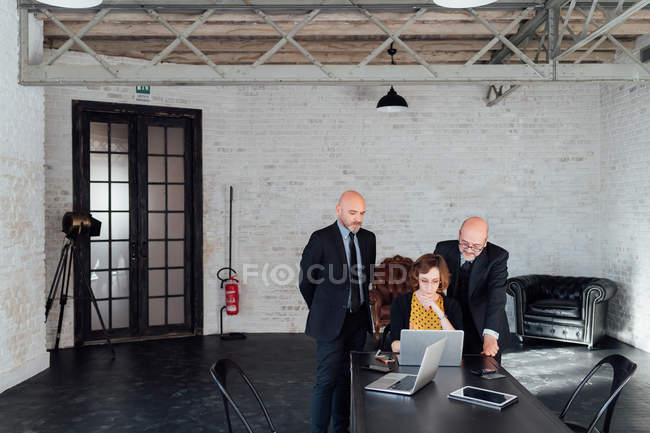 Три колеги дивляться на ноутбук разом — стокове фото