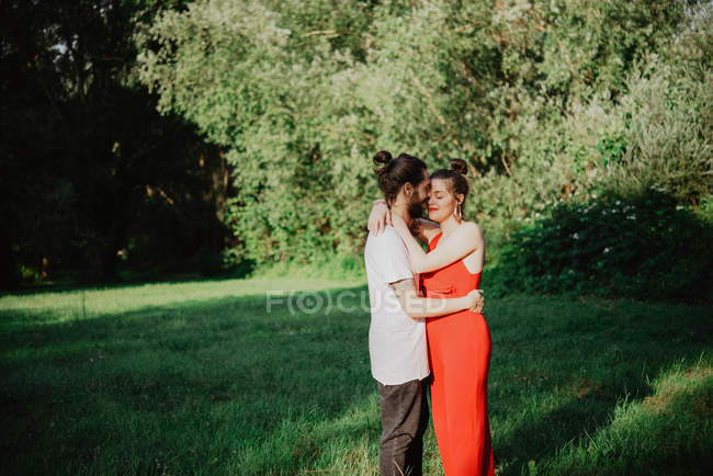 Portrait of young couple hugging in garden — Stock Photo