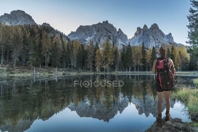 Female Hiker by lake looking at mountain ranges, Dolomites, Cortina dAmpezzo, Veneto, Italy — Stock Photo