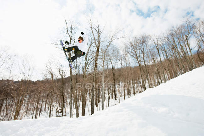 Visão de baixo ângulo do snowboarder pulando no ar — Fotografia de Stock