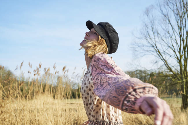 Hippy style woman dancing among reeds — Stock Photo