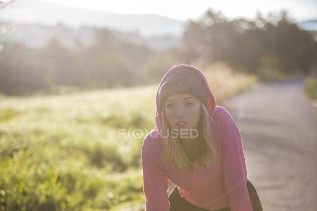 Mujer joven tomando un descanso de hacer ejercicio al aire libre - foto de stock