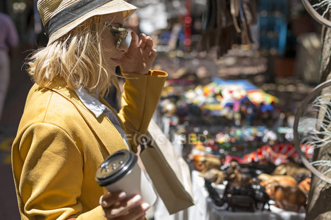 Mujer con taza desechable en el puesto de mercado al aire libre, Ciudad del Cabo, Sudáfrica - foto de stock