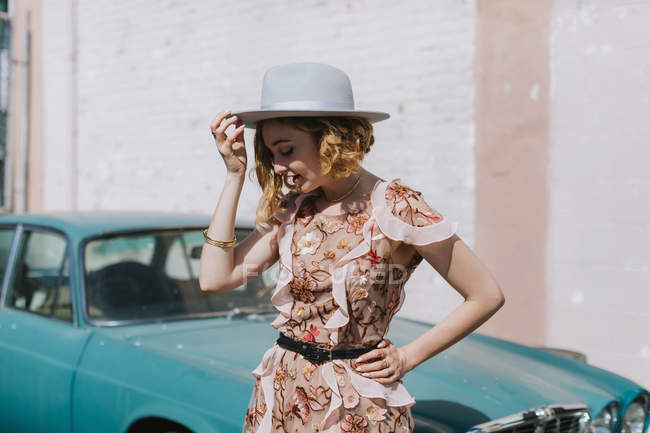 Вид сбоку на женщину в шляпе на винтажном автомобиле — стоковое фото