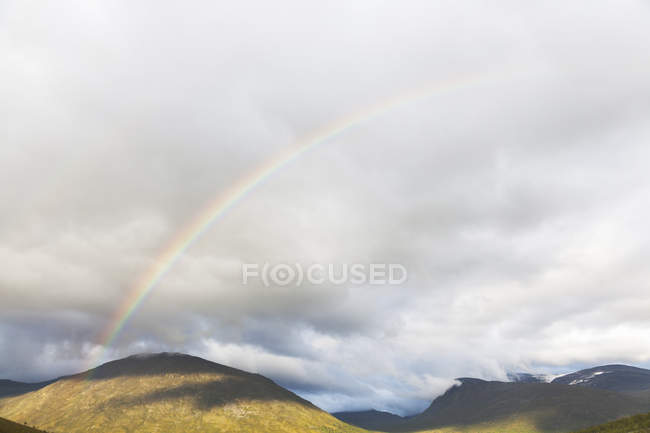Rainbow over mountain landscape, Parc national de Jotunheimen, Lom, Oppland, Norvège — Photo de stock