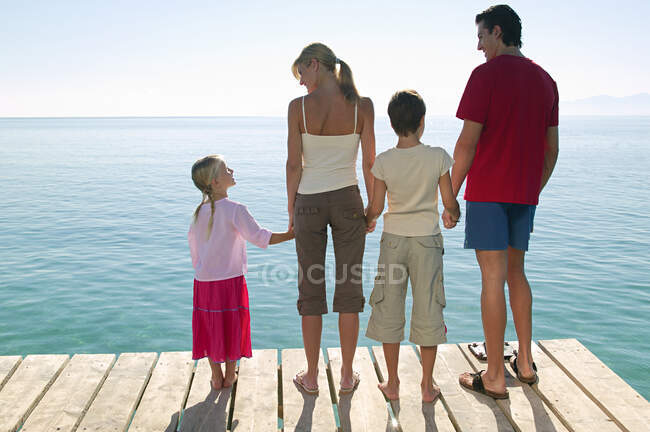 Vue arrière de la famille debout sur la jetée — Photo de stock