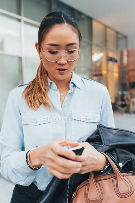 Retrato de mujer de negocios usando teléfono inteligente al aire libre - foto de stock