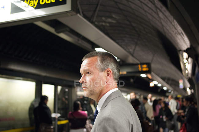 Uomo d'affari alla stazione della metropolitana che guarda altrove — Foto stock