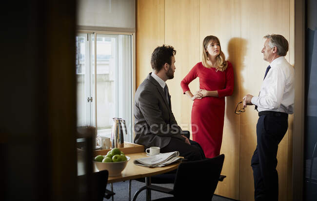 Mujer de negocios y hombres teniendo reunión de oficina - foto de stock